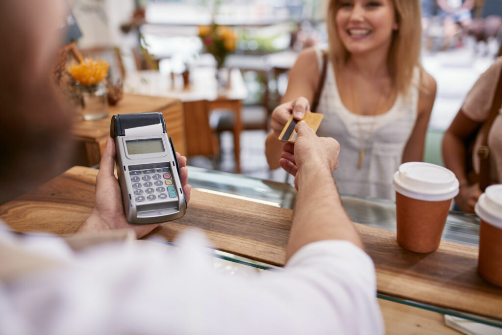 Cliente mulher pagando no cartão um café.