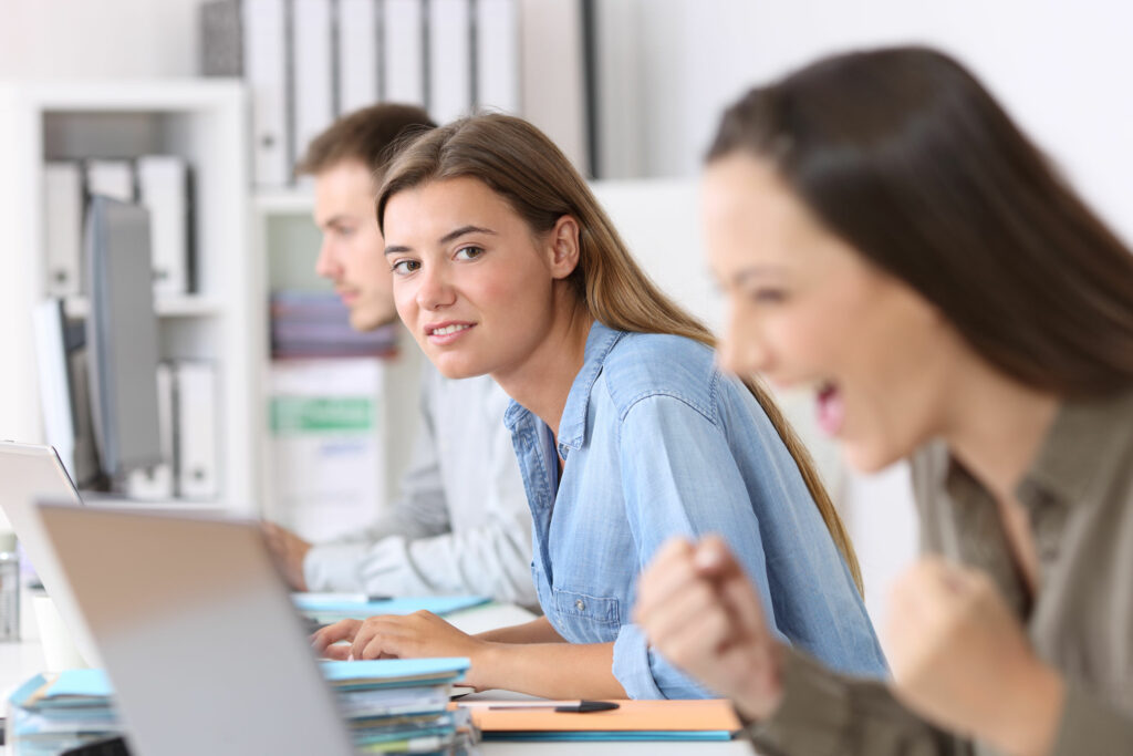 Retrato de funcionária com inveja de colega de trabalho em escritório.