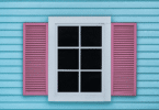 Janela metade rosa e branca em uma casa azul