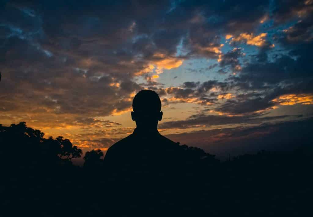 Homem olhando para o céu anoitecendo