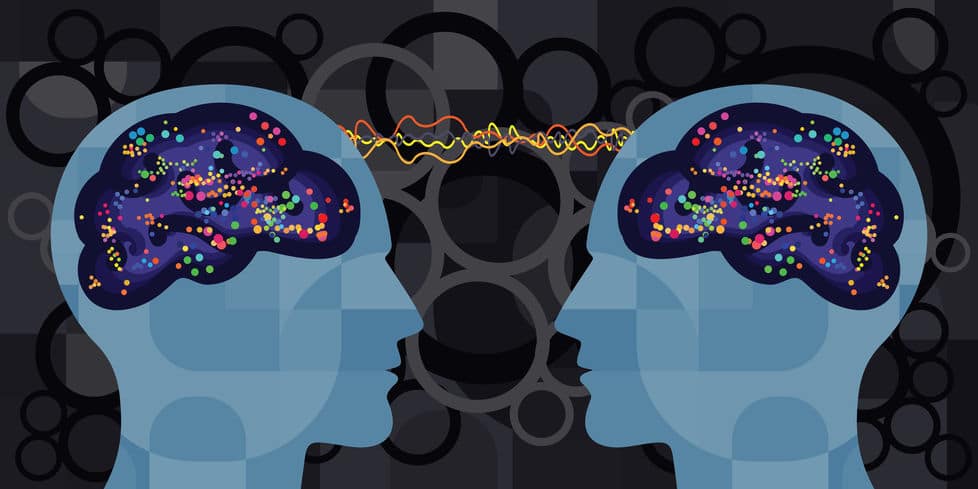 Duas silhuetas olhando-se, com seus cérebros conectados por fios coloridos 