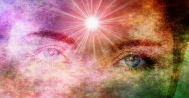 Olhos de mulher esmaecidos por cores de arco íris. Há um forte ponto de luz um pouco acima do meio das sobrancelhas, na região esotericamente reconhecida como "terceiro olho"