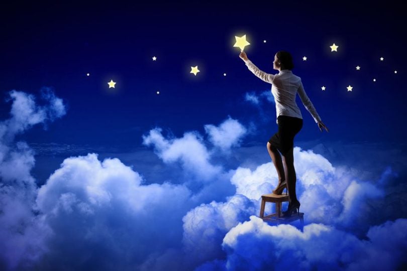 Homem em pé sobre nuvem pegando uma estrela