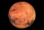 Planeta Marte, vermelho e com crateras em sua superfície.