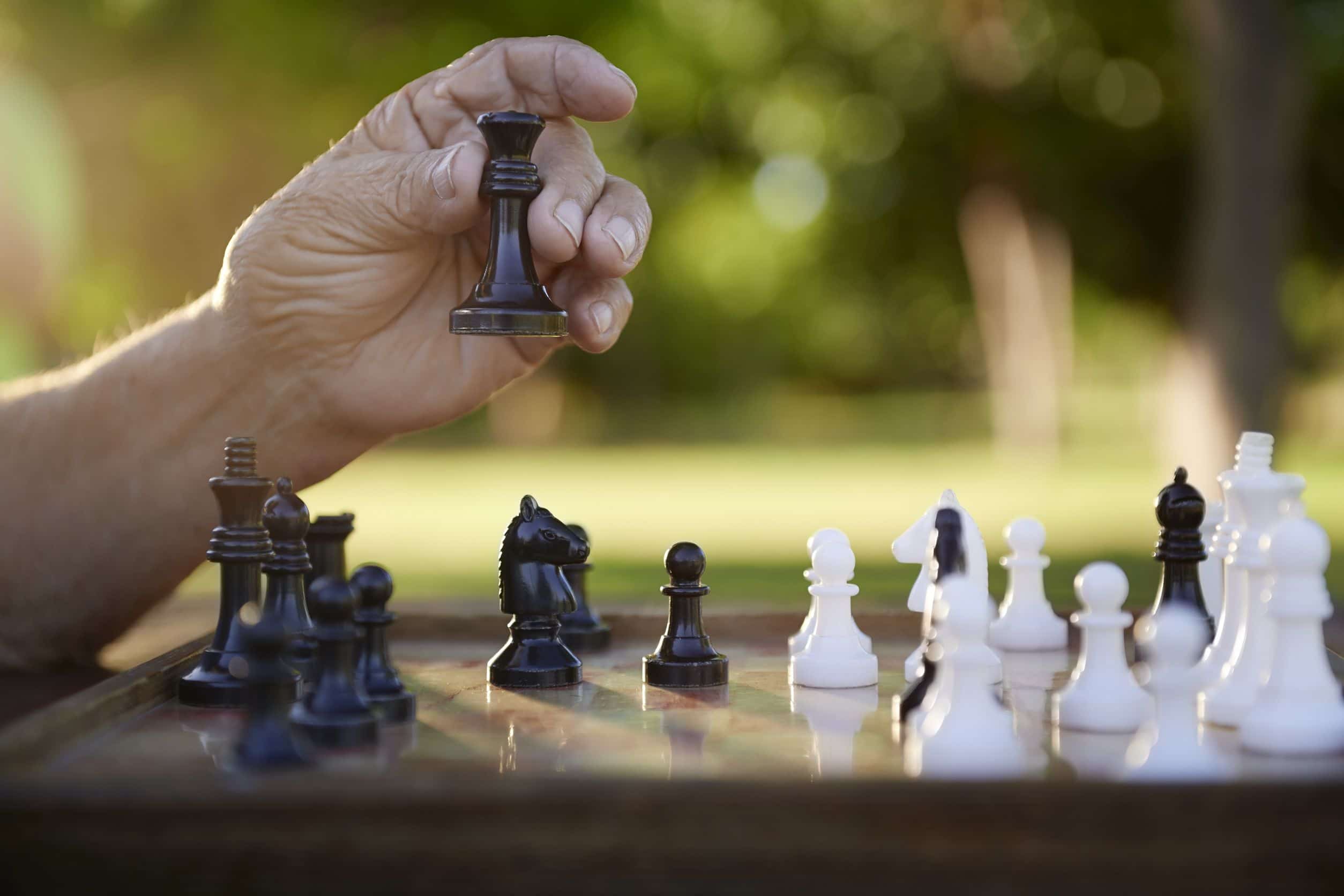 Mão de homem jogando xadrez em um parque