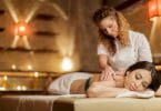 Terapeuta fazendo massagem em paciente deitada relaxada na maca