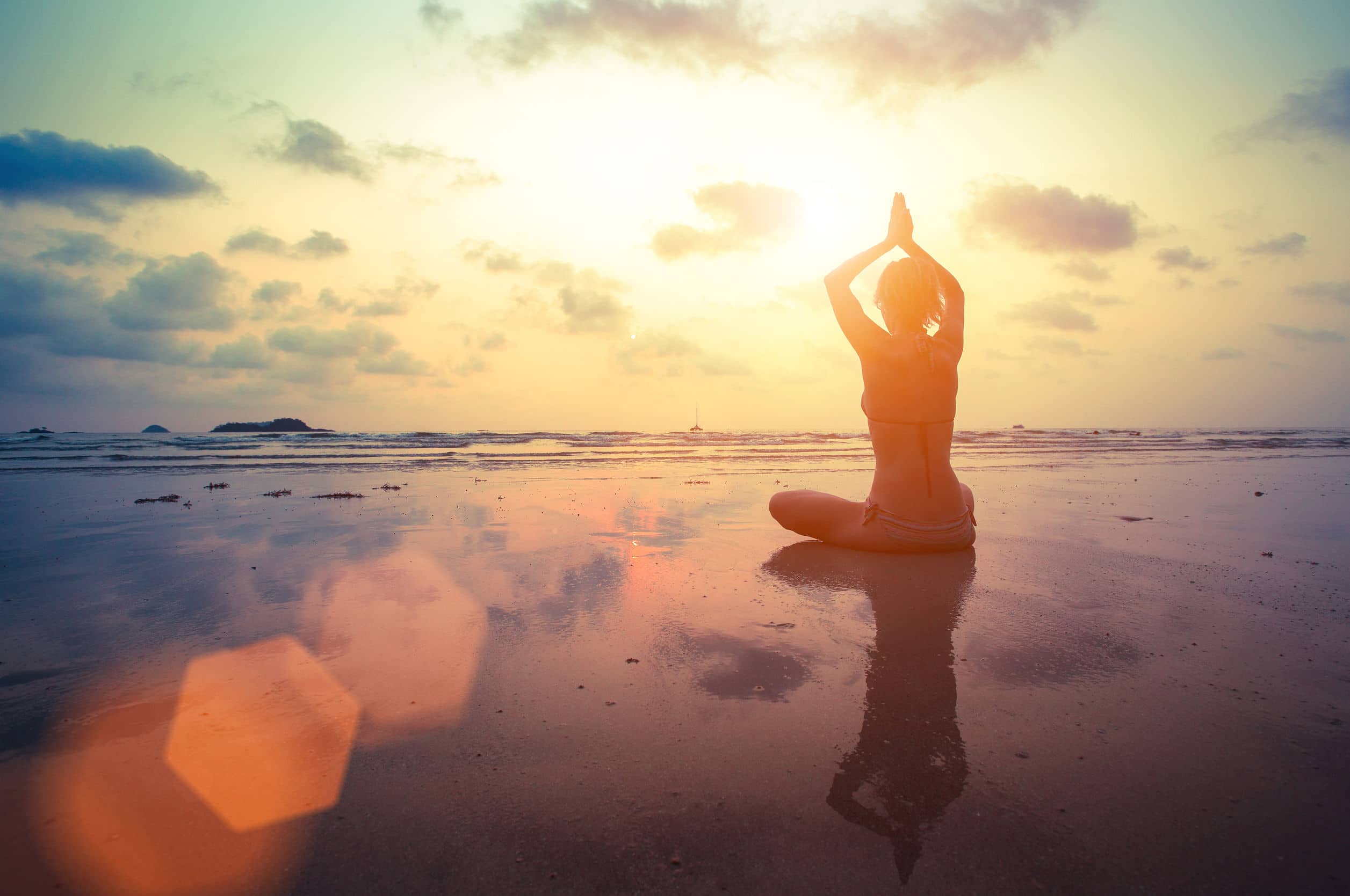 Foto Uma mulher sentada em uma posição de yoga na praia – Imagem de Ioga  grátis no Unsplash