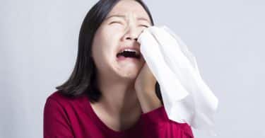 Mulher chorando com lenço secando as lágrimas