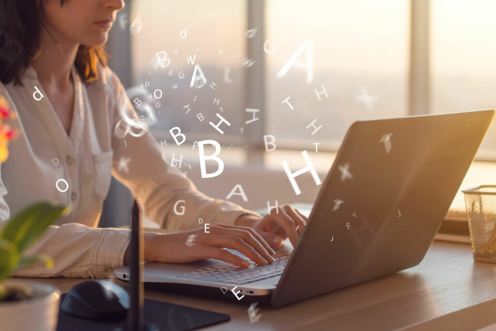 Mulher sentada em uma mesa de escritório, digitando em seu notebook