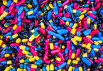 Diversas pílulas de remédios coloridas vistas de cima