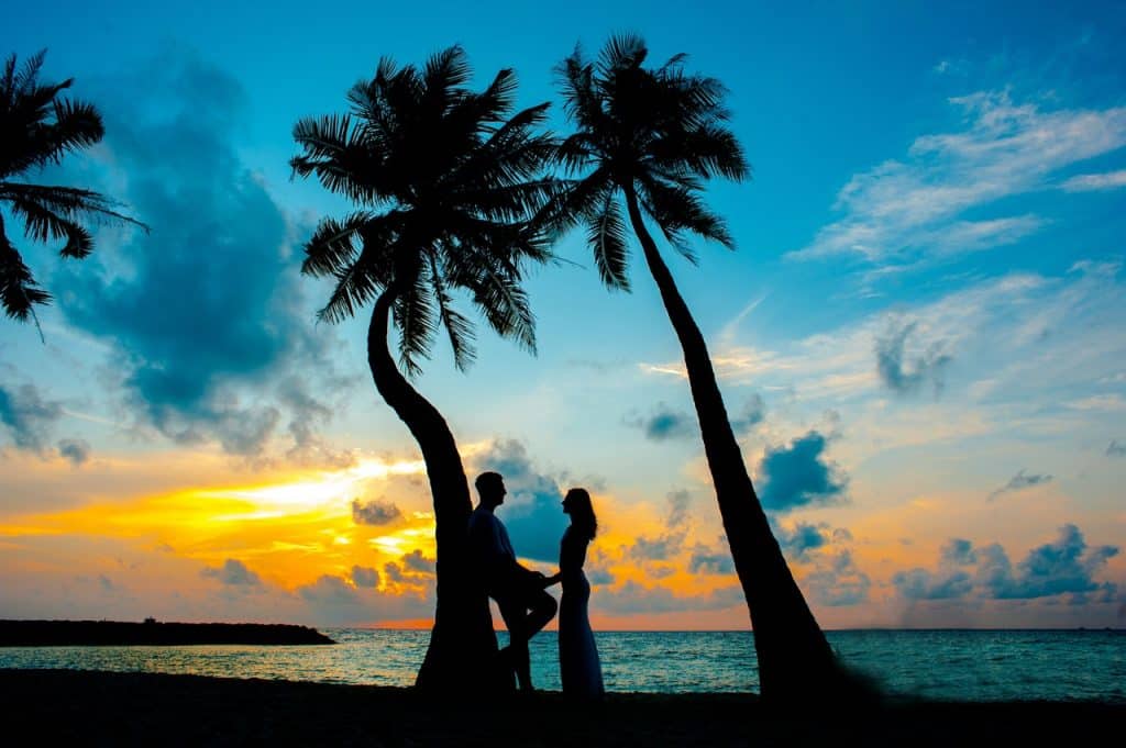 Casal em clima de romance aproveitando o pôr do sol. 