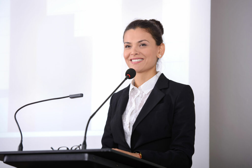 Mulher sorridente falando em um microfone.