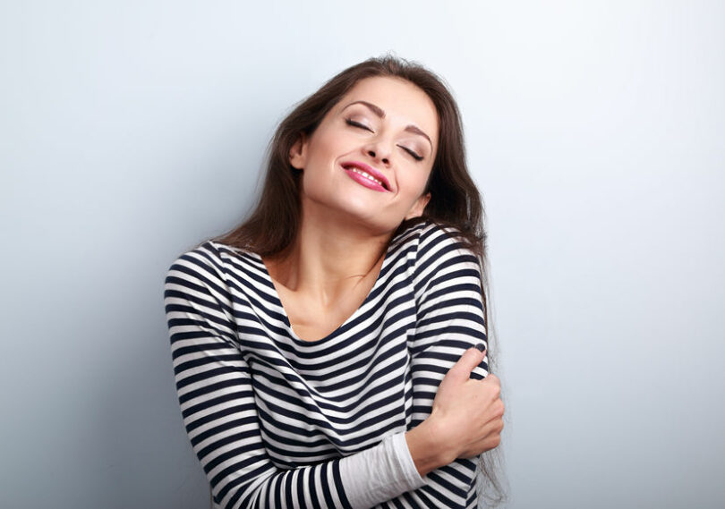 Mulher feliz abraçando a si mesmo