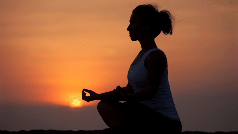 Silhueta de uma mulher fazendo yoga