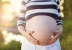 Barriga de grávida com mãos acariciando