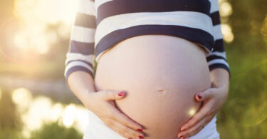 Barriga de grávida com mãos acariciando