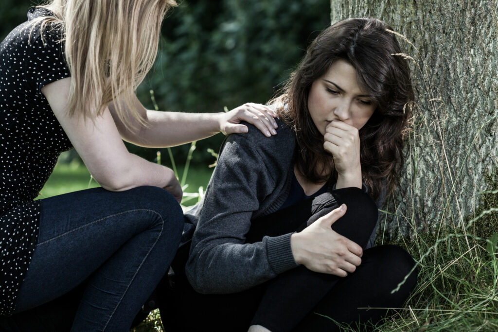 mulher consolando outra em luto