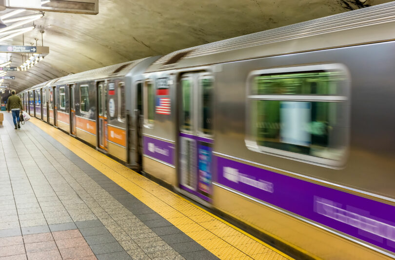 Estação de metrô em Nova York, com o trem passando em alta velocidade.