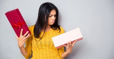 mulher infeliz segurando a caixa de presente