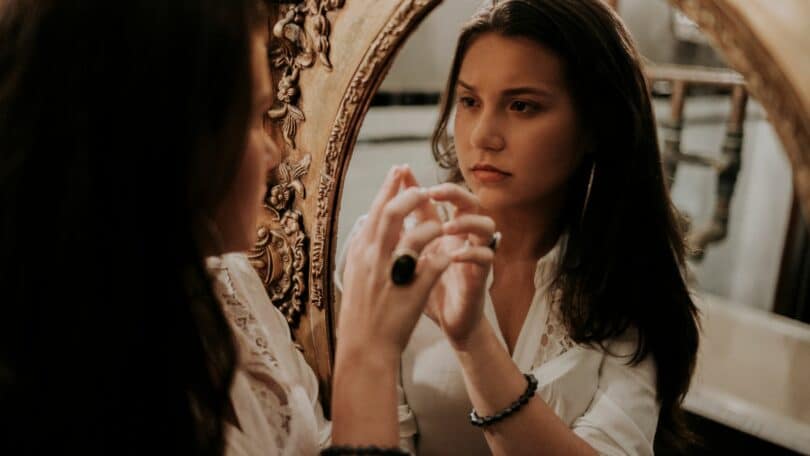 Mulher se olhando no espelho.