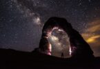 Pessoa em arco de pedra olhando céu