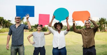 Pessoas diferentes segurando balões de fala coloridos