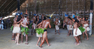 Indígenas realizando um ritual dentro de uma oca
