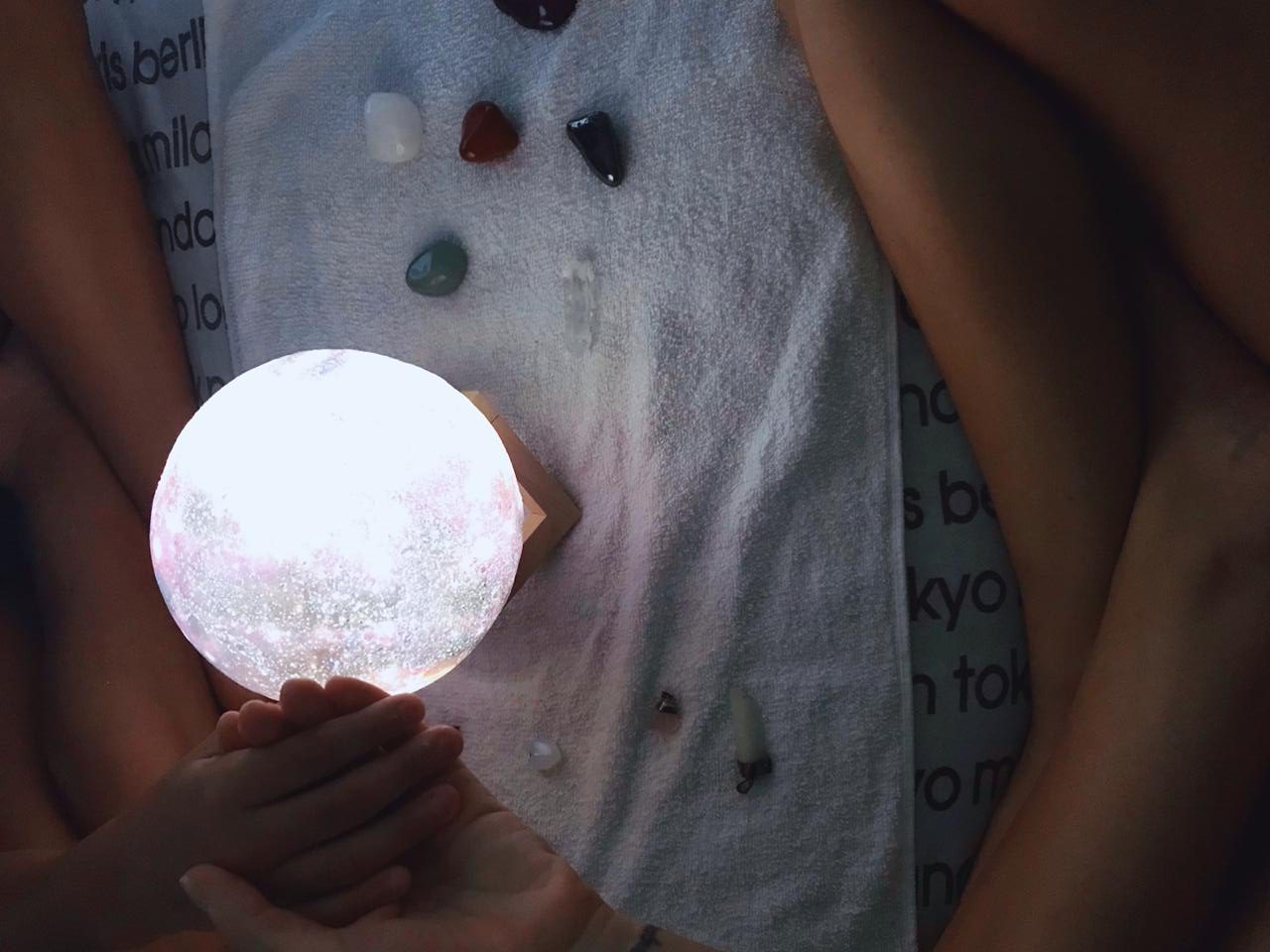 Autora e filha meditando com luz e pedras.