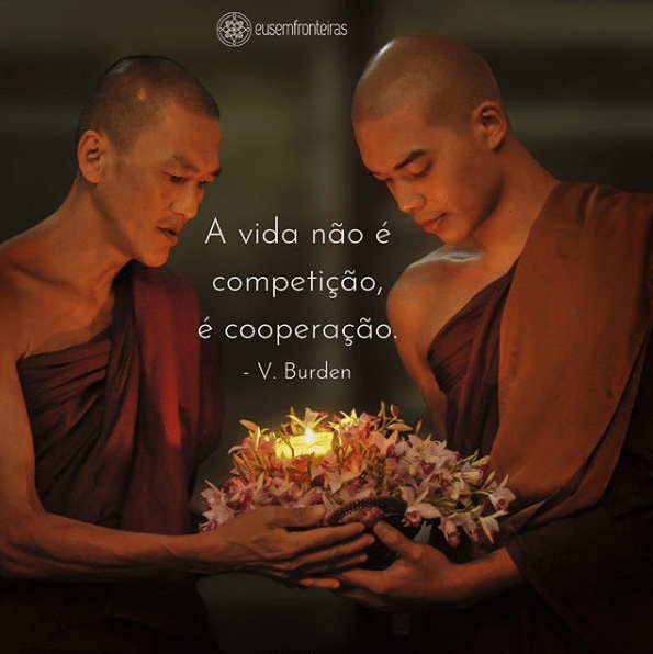 Foto de dois monges ascendendo uma luz, com a frase "A vida não é competição, é cooperação " escrita em branco.