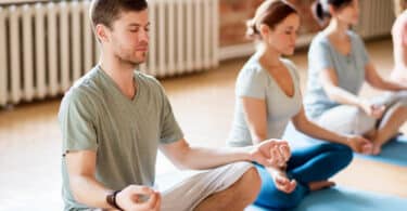 Homem em foco meditando em posição de lótus
