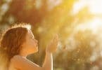 Criança iluminada pelo sol com mãos para o alto