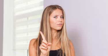 Imagem de uma mulher sinalizando a expressão de não com a mão