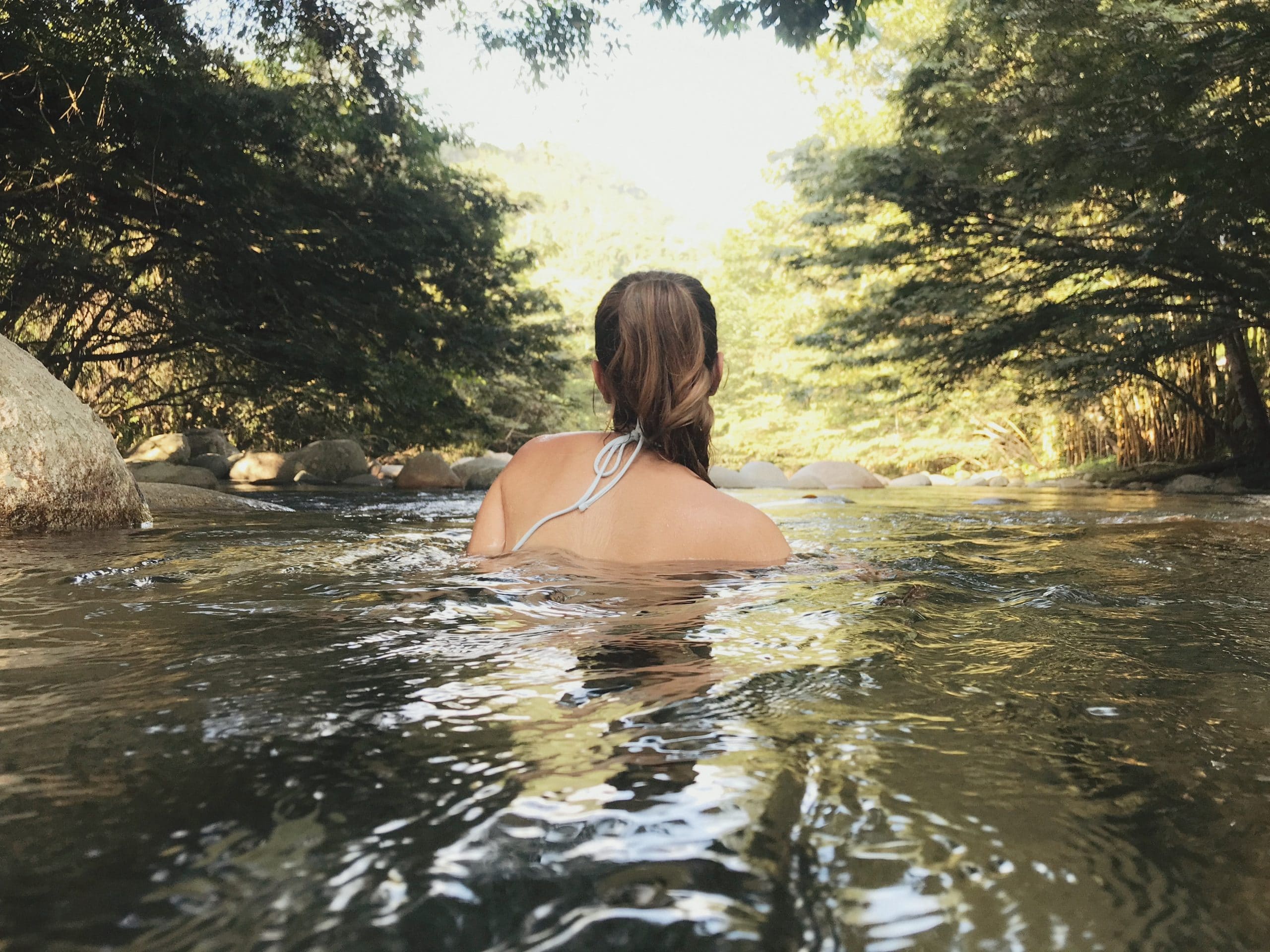 Mulher de costas em um lago.