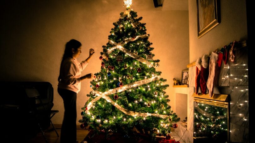 Mulher enfeitando árvore de natal