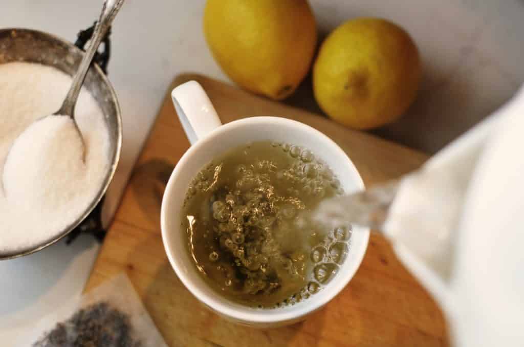 Água quente sendo despejada em um xícara de chá