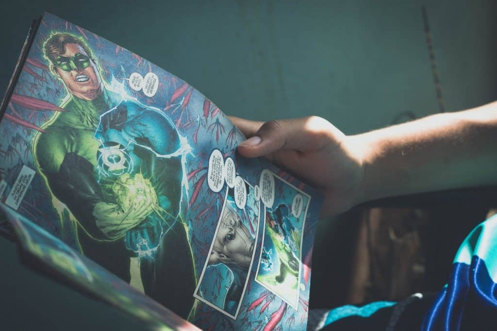 Um menino segurando uma revista de histórias em quadrinhos.