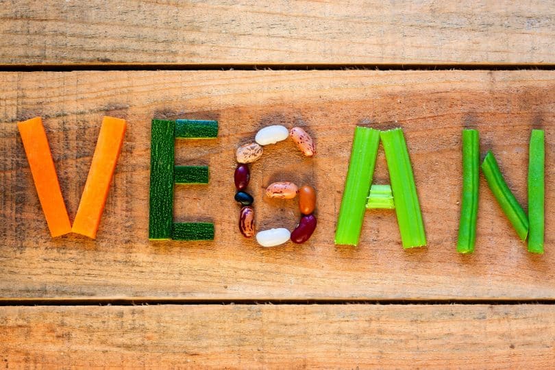 Palavra "vegan" formada por vegetais e oleaginosas.