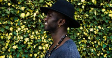 Perfil de homem negro sorrindo.