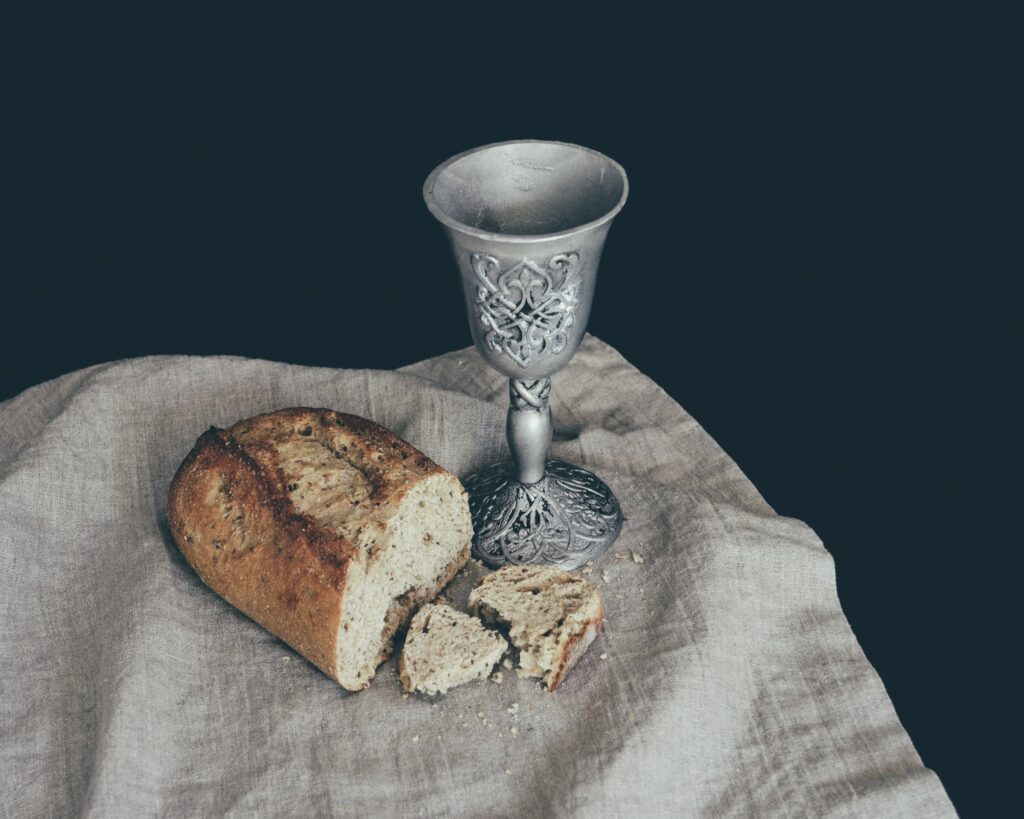 Pão com taça de vinho ao lado.