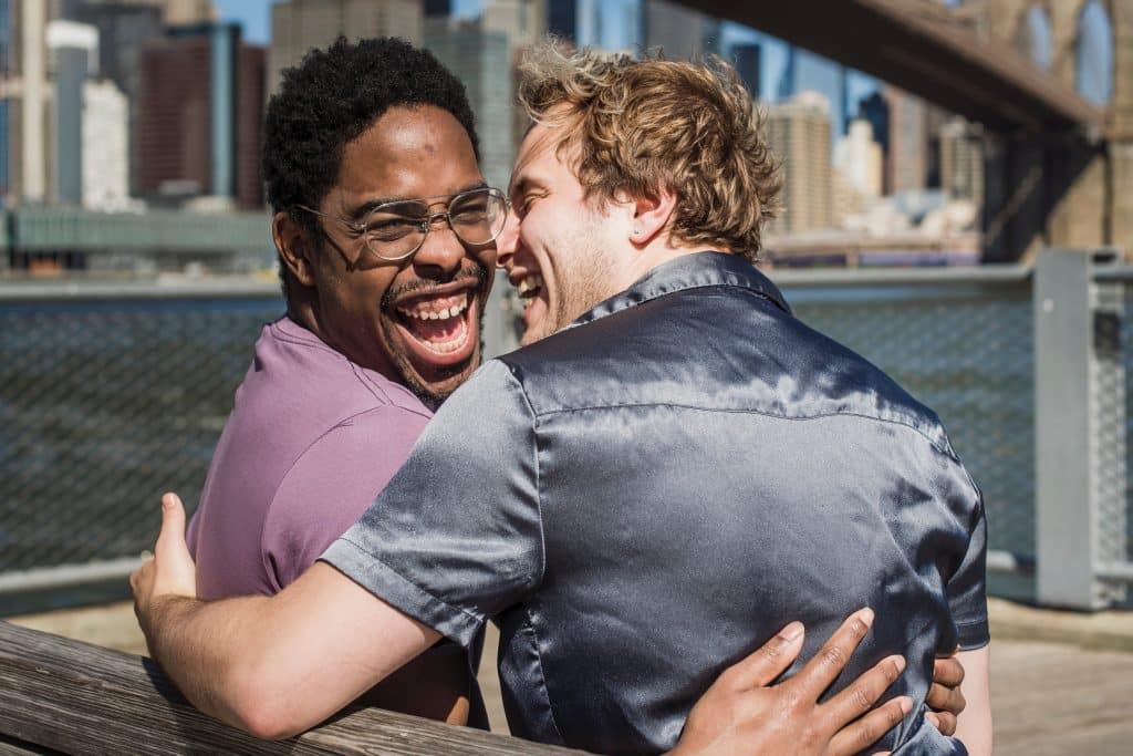 Dois homens sorrindo abraçados