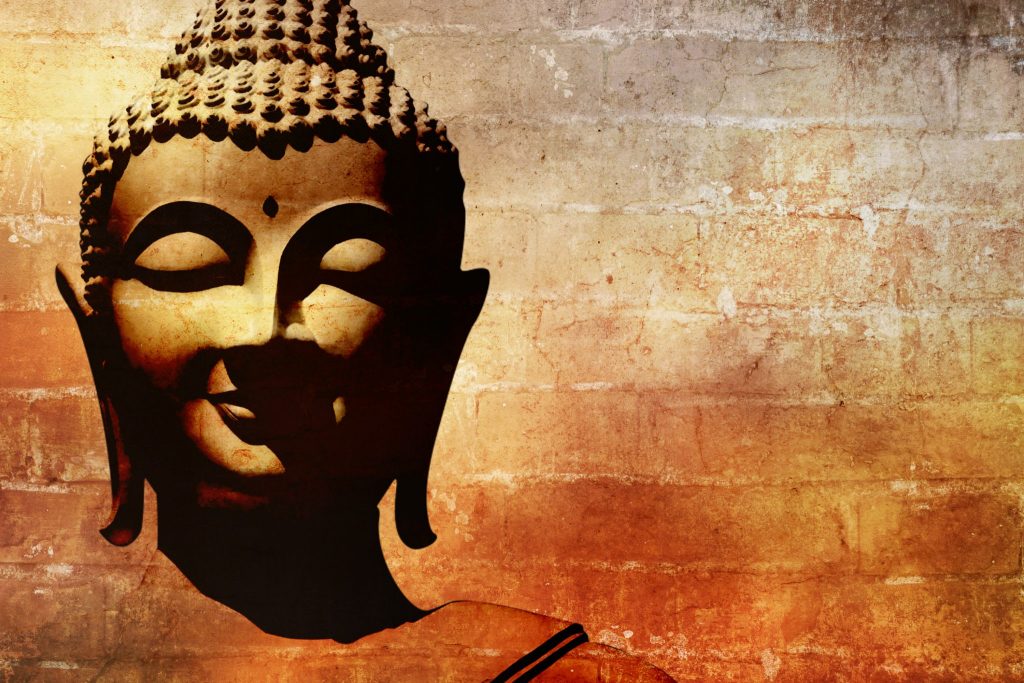 Imagem do rosto de Buda na cor dourada.