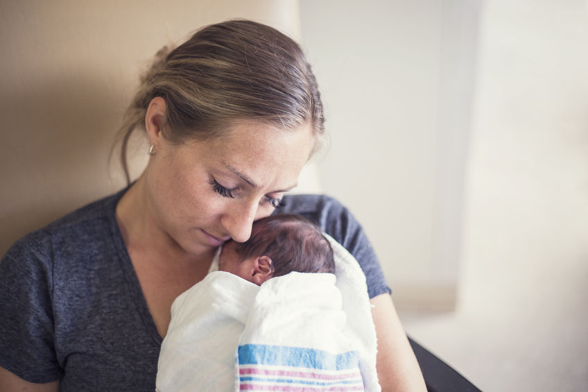 Mãe com bebê no colo.