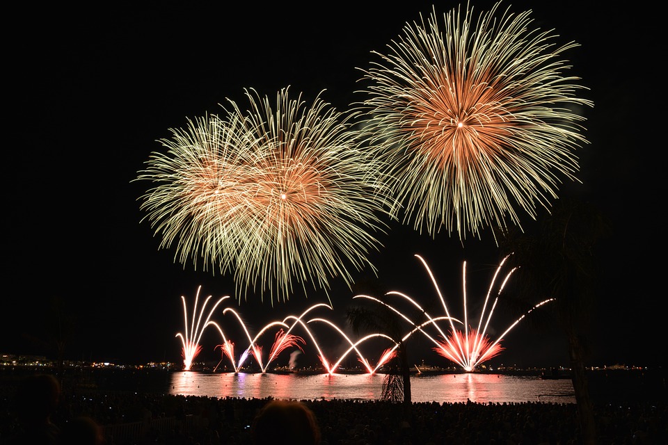Paisagem urbana com fogos de artifício e um rio.