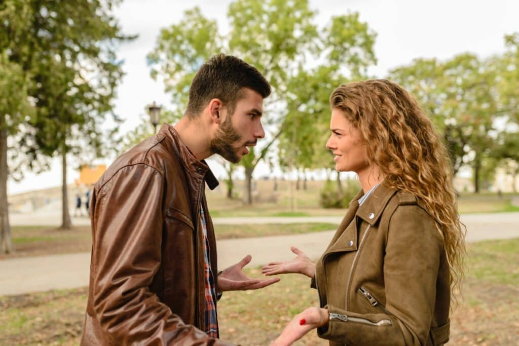 Homem e mulher discutindo entre si em um parque.