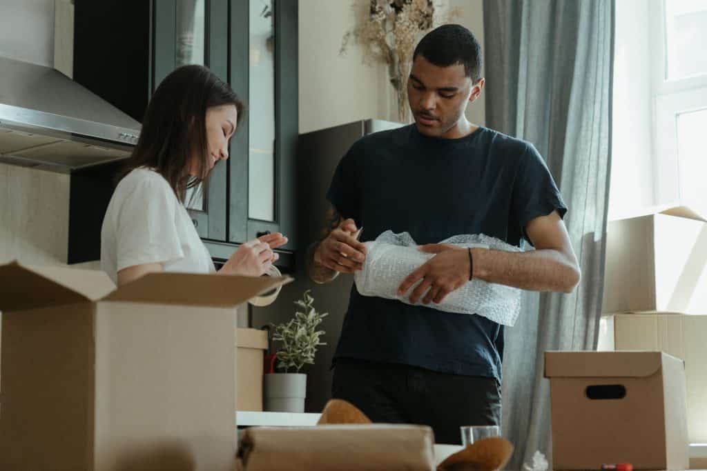 Homem e mulher empacotando as coisas da casa para a mudança.