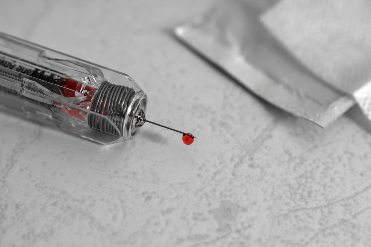 Ponta de seringa com gota de sangue