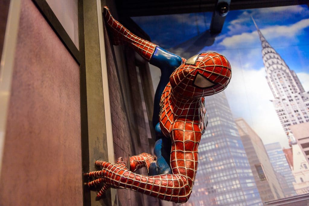 Imagem do homem aranha escalando uma parede no centro de Nova York.
