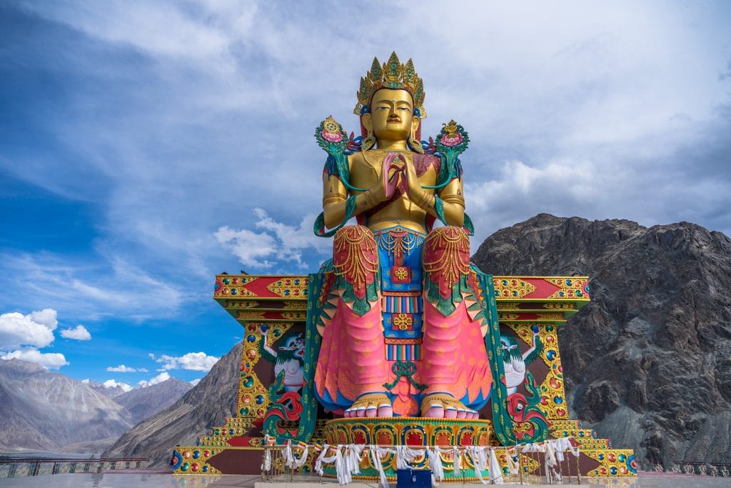 Estátua bem colorida trazendo a imagem de Buda no estilo tibetano.