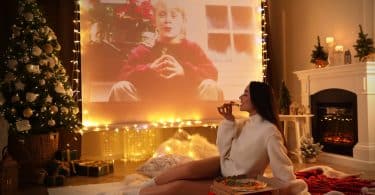 Mulher comendo pizza em um lugar enfeitado de natal.