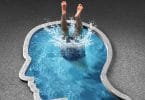 Pessoa mergulhando em piscina com formato de silhueta de uma cabeça humana.